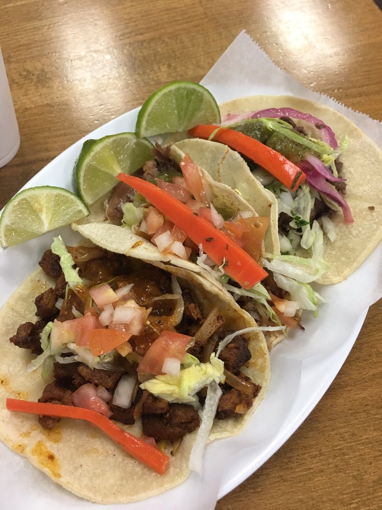Three street tacos on handmade corn tortillas with lime