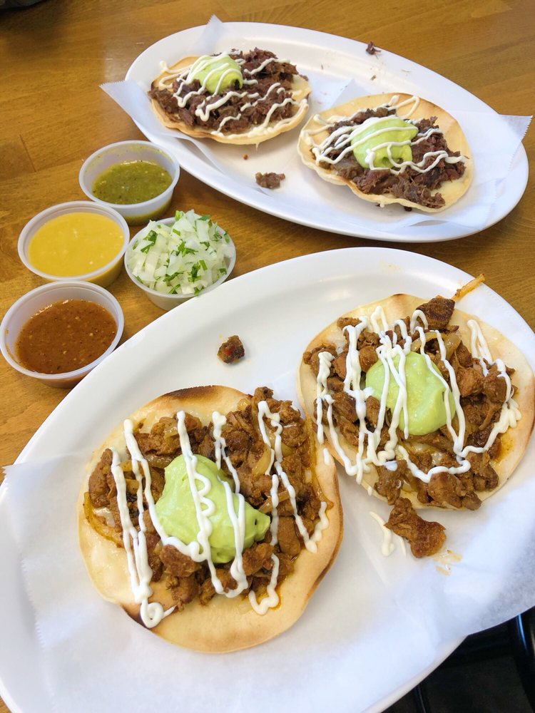 Vampiros topped with guacamole and sour cream alongside salsas